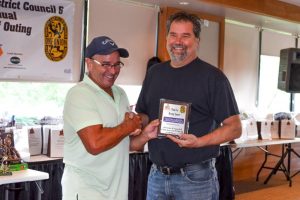 Don Long, representative for Thomarios, accepts appreciation plaque for their Beverage sponsorship.